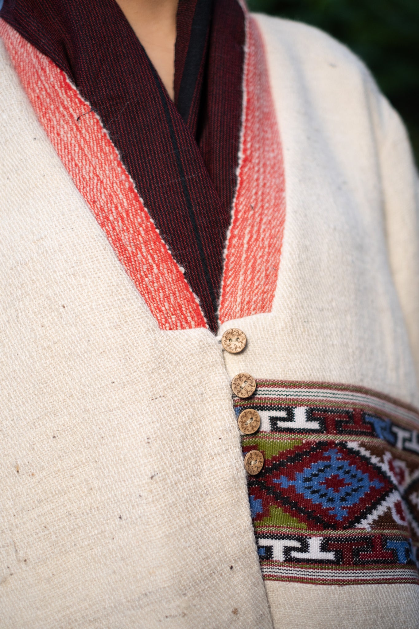 Close-up of a traditional garment with intricate patterns and buttons.